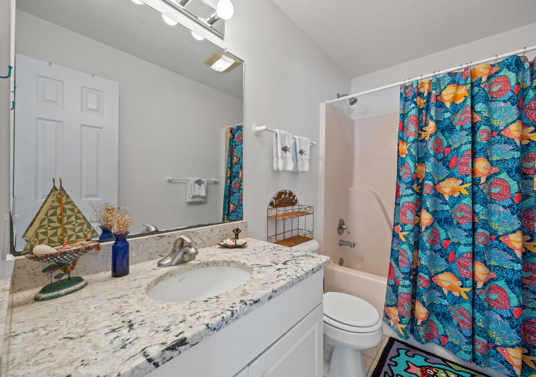 Your vibrant bathroom features granite countertops and tropical-themed touches that make your daily routine feel like a colorful escape.