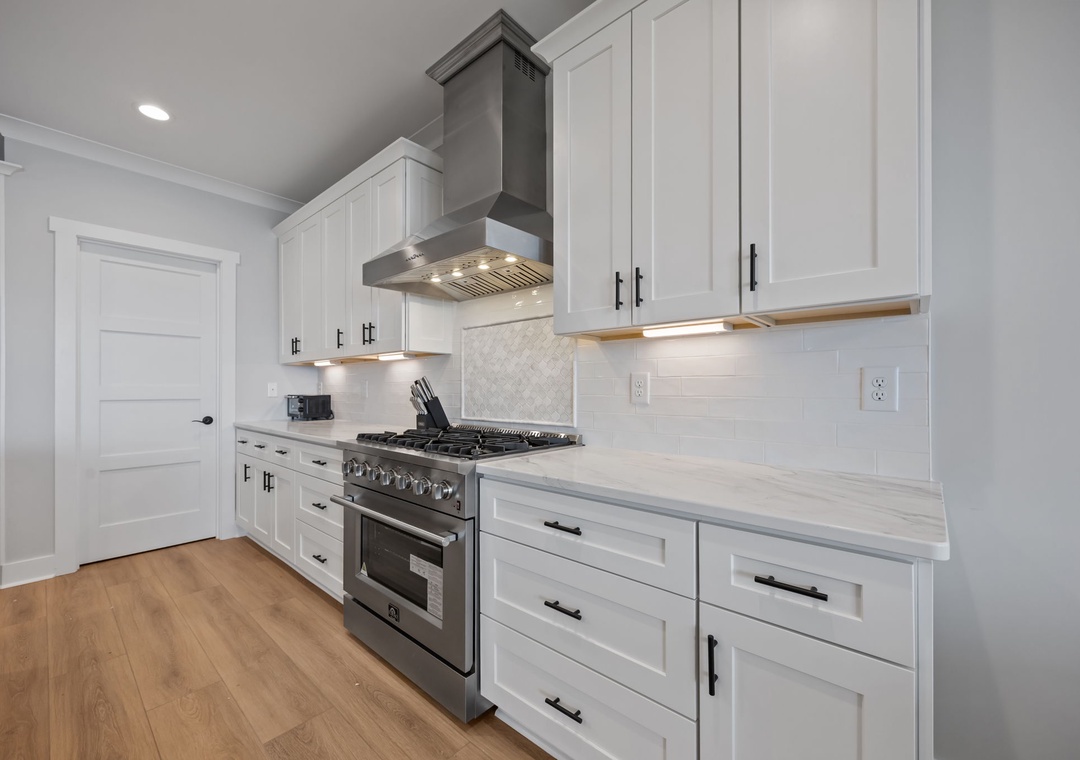 Your culinary dreams come true in this pristine white kitchen with premium stainless appliances and gleaming countertops.