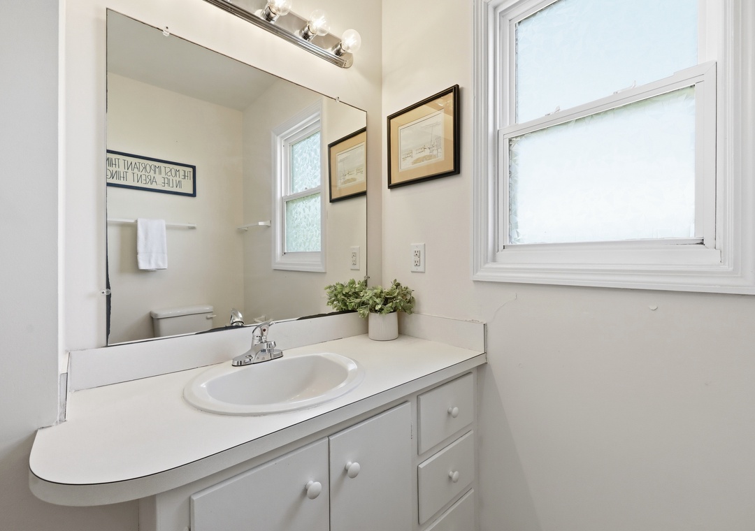 Step into your private bathroom, where soft natural light, a spacious vanity, and fresh, calming touches create a peaceful retreat for your morning routine.