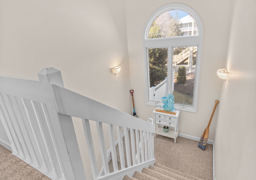 Bright staircase landing with charming arched window offering natural light and peaceful views of your surroundings.