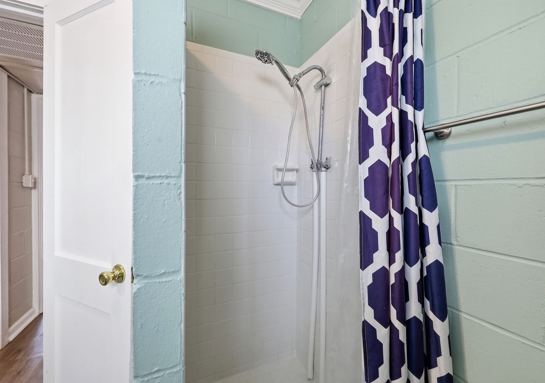 Rinse away the day in your private walk-in shower, styled with a cheerful geometric curtain and soothing coastal hues that make every refresh feel like a mini spa moment.