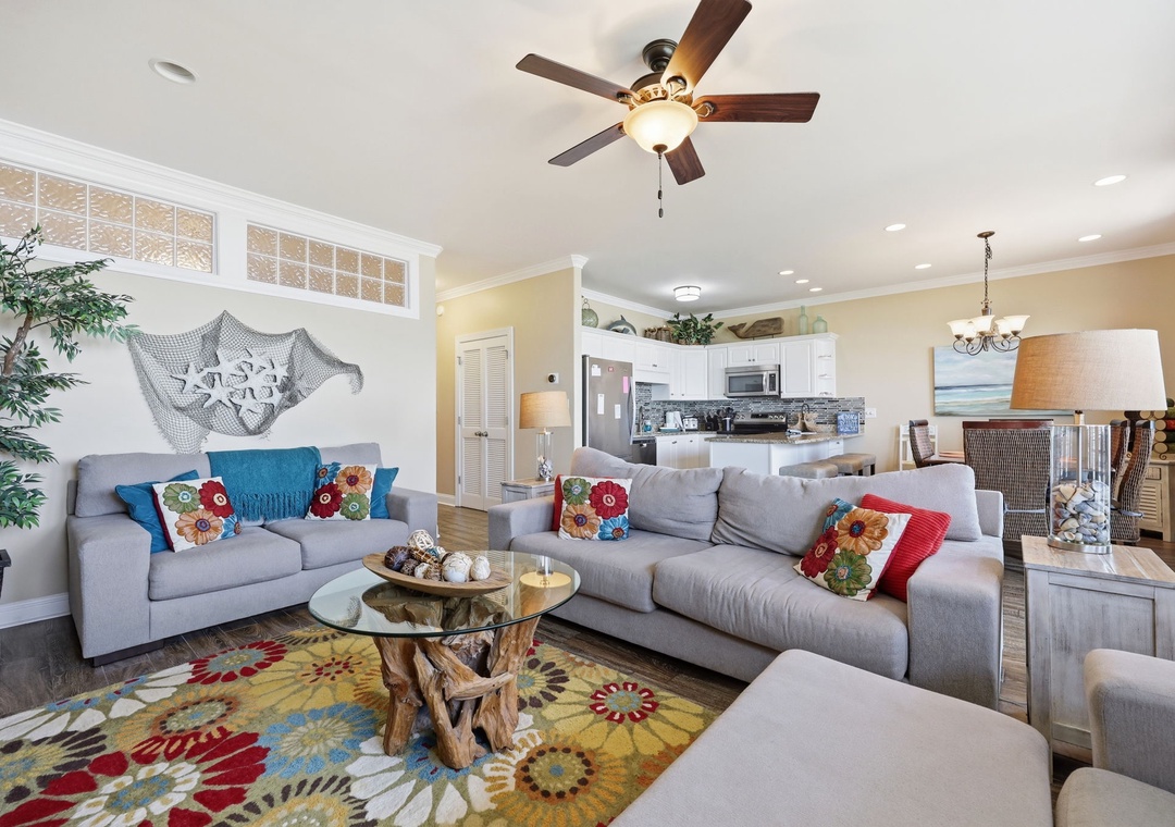 Unwind on plush sofas in this bright, coastal-themed space where beach-inspired décor meets modern comfort. The open layout flows into a fully equipped kitchen—perfect for family gatherings after sunny days exploring.