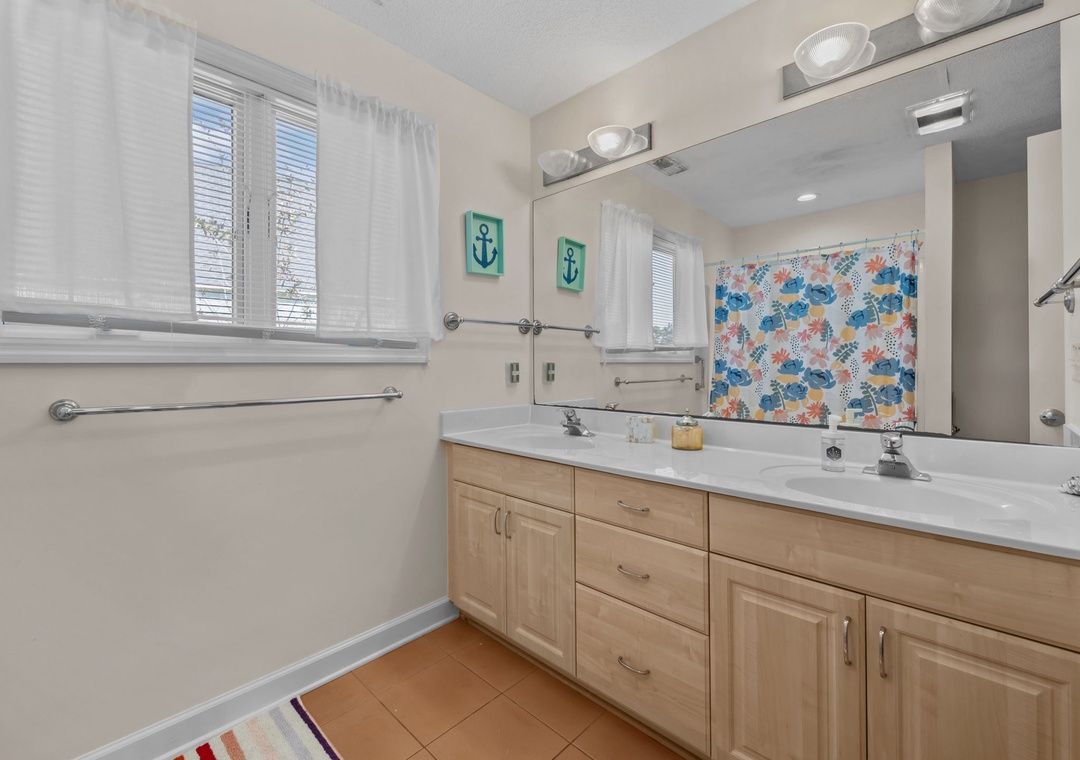 Start your day in this bright bathroom with dual sinks and nautical touches - perfect for sharing morning routines.
