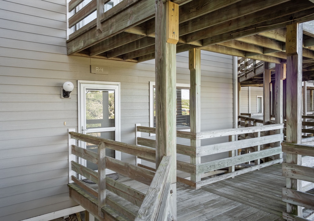 Multi-level wooden deck structure featuring rustic charm with natural wood beams and railings surrounding the property entrance.