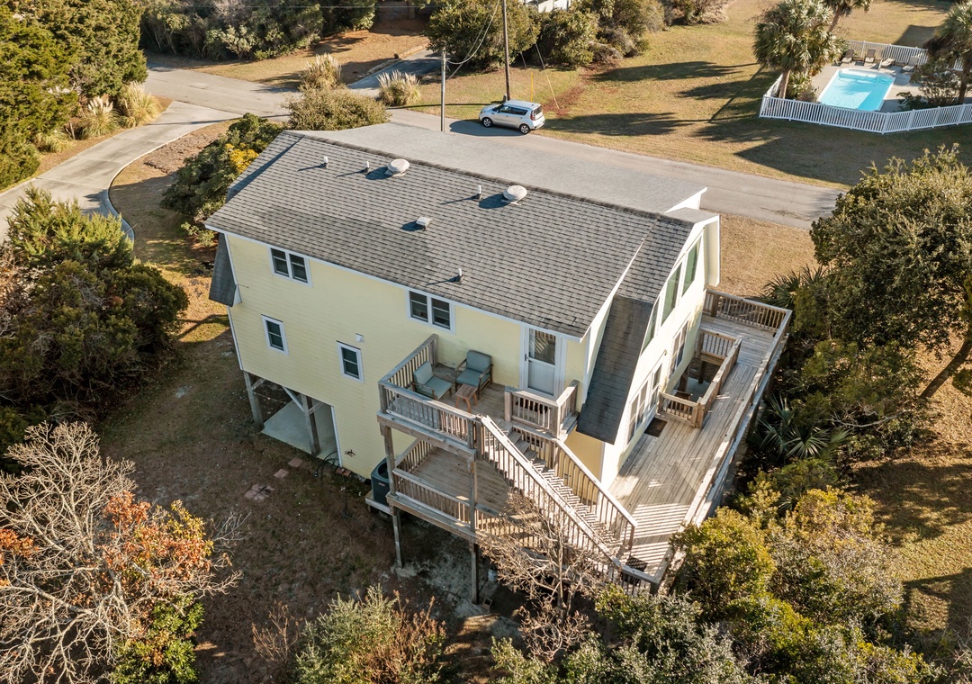 Elevated beachside home featuring expansive wraparound decks and multi-level design in a peaceful coastal community setting.