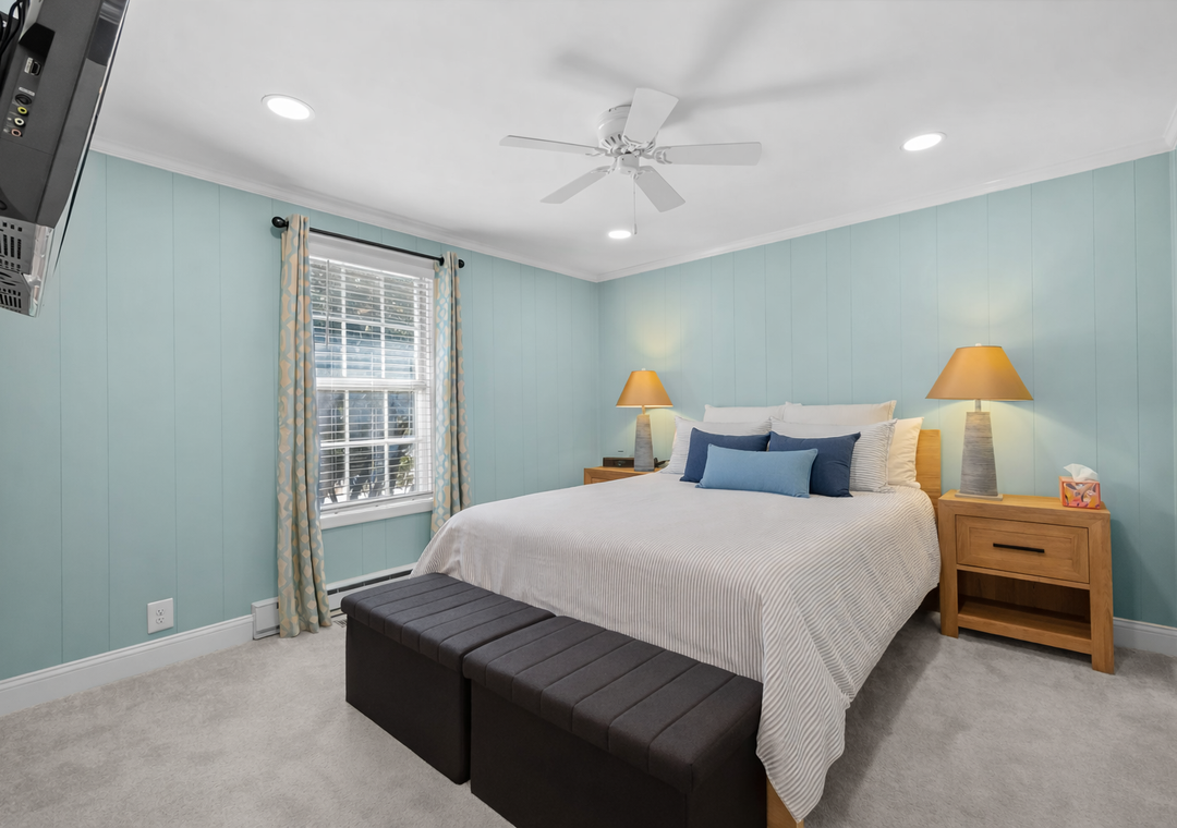 Drift off peacefully in your serene bedroom featuring calming blue walls, a cozy king bed, and gentle lighting for ultimate relaxation.