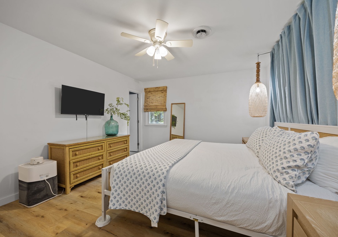 Drift off in your serene coastal bedroom with crisp linens, warm wood accents, and gentle ceiling fan keeping you comfortable.