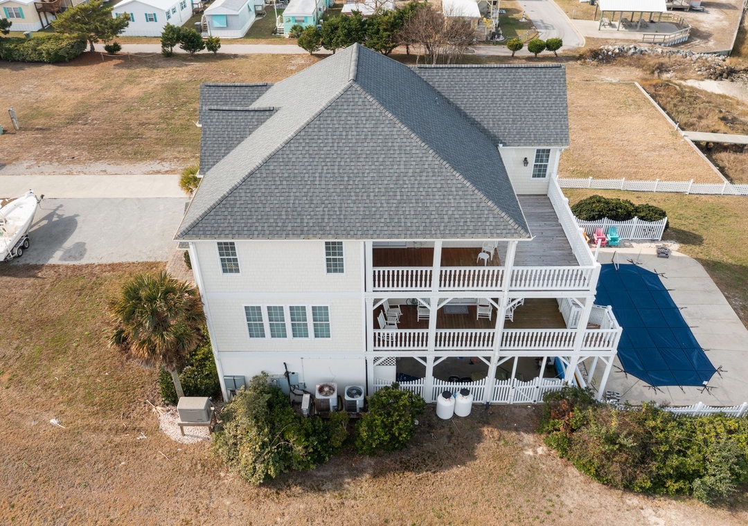A stunning white coastal home featuring wraparound porches, private pool, and prime location in a peaceful beach community.
