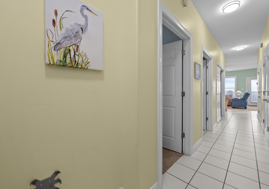 Your private hallway leads to cozy rooms, with beautiful coastal artwork and clean tile floors welcoming you home after beach days.