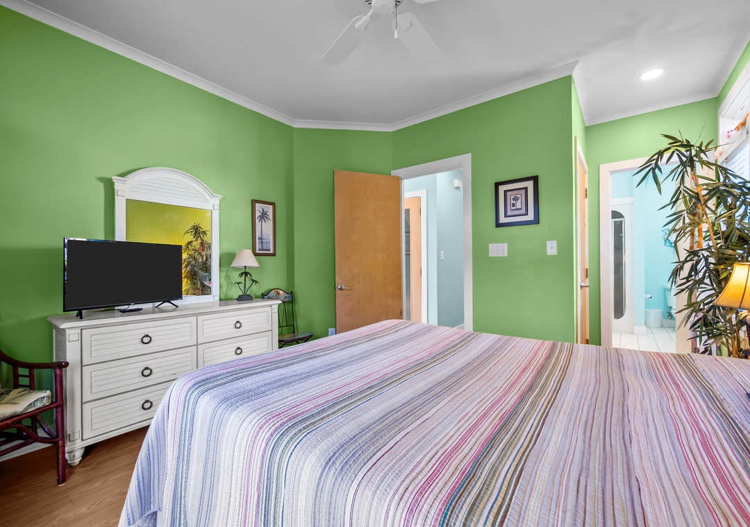 Unwind in your vibrant retreat with cheerful green walls, comfortable bedding, and tropical touches that create a refreshing escape.