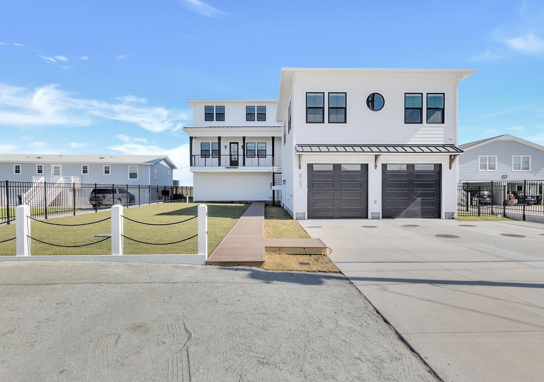 Modern coastal vacation home featuring a two-car garage, contemporary architecture, and coastal neighborhood setting with easy beach access.