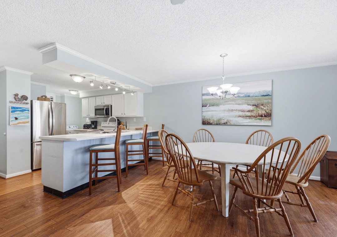 Gather around the generous dining table with seating for eight, opening seamlessly to your fully equipped kitchen with stainless steel appliances and breakfast bar.