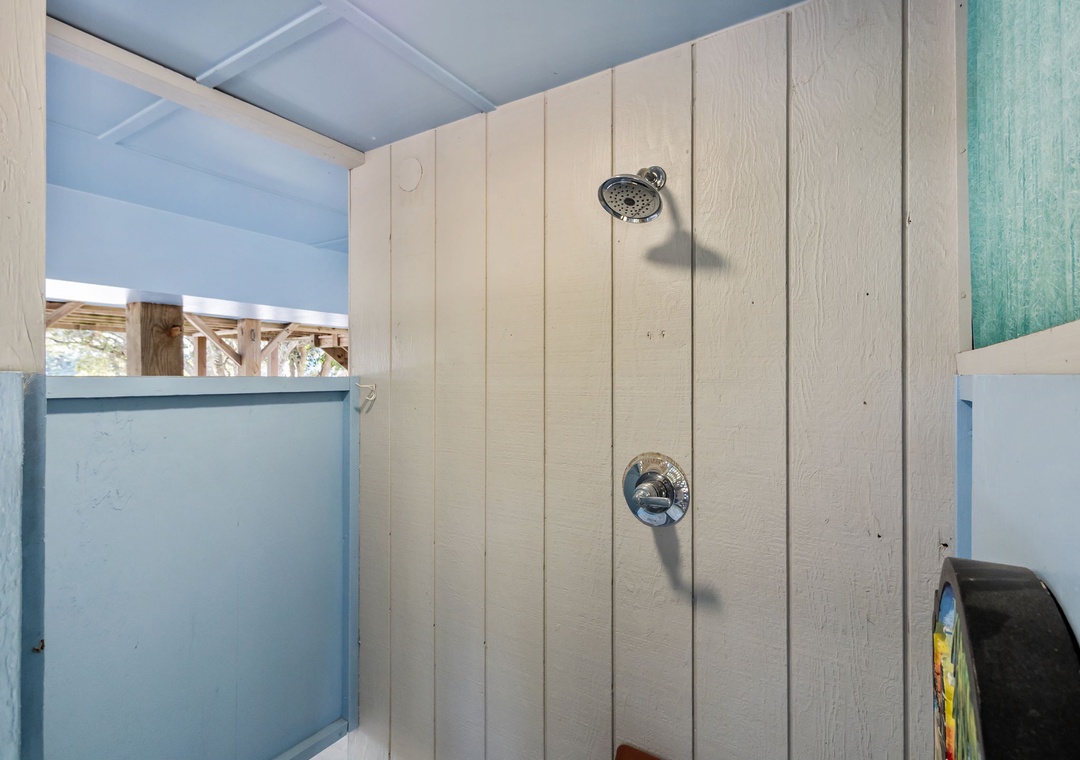 Rinse away your worries in this rustic outdoor shower with fresh ocean breezes and natural wood accents for an authentic coastal experience.