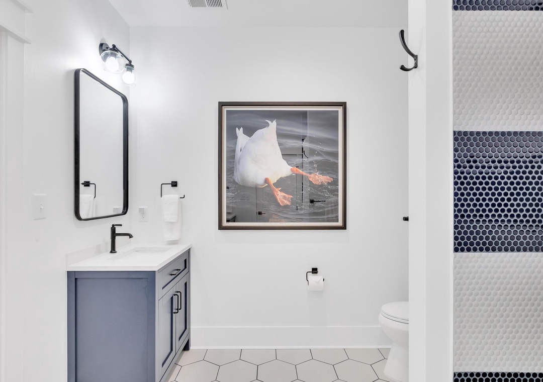 Step into your modern sanctuary with bold mosaic tile, sleek black fixtures, and artistic touches that bring personality to every detail.