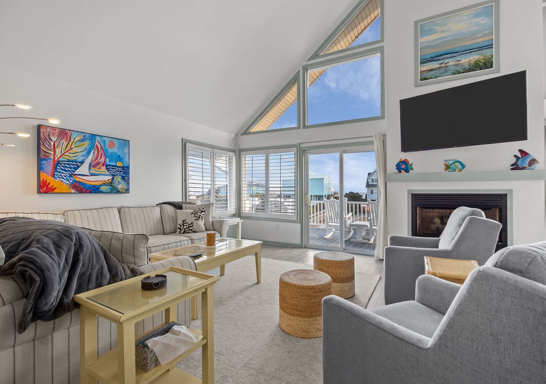 Sink into plush seating by your cozy fireplace while ocean breezes flow through expansive windows in this bright, art-filled retreat.