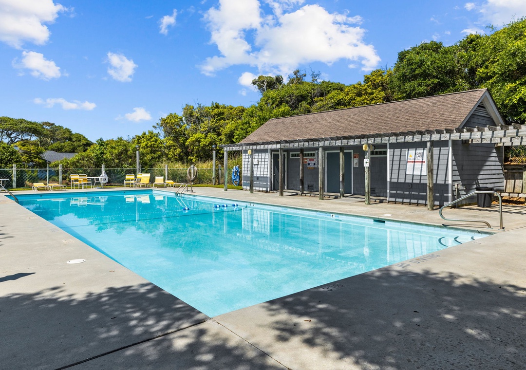 Refreshing community pool surrounded by lush greenery, perfect for your morning laps or afternoon relaxation under the sunny skies.