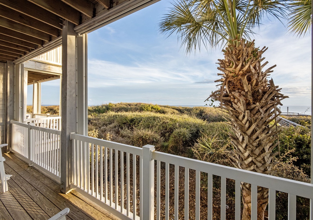 Relax on your private covered balcony overlooking coastal dunes and palm trees, perfect for morning coffee or evening unwinding.