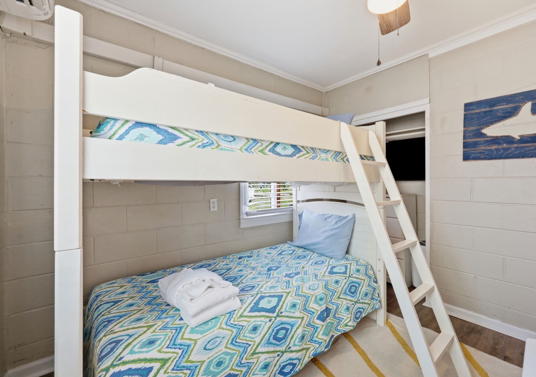 Climb up to your cozy coastal retreat where cheerful blue and green bedding creates a beach-inspired haven for restful nights and lazy mornings.