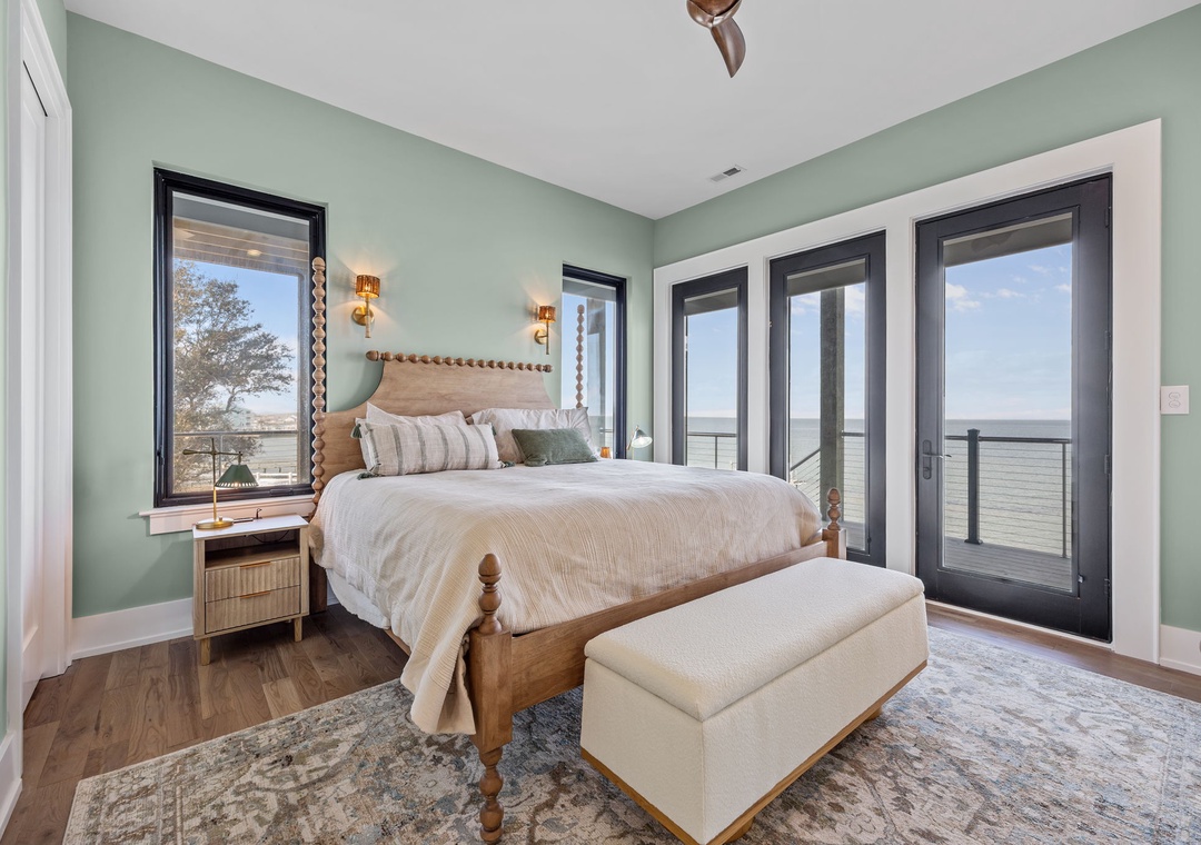 Wake up to stunning water views from your serene bedroom sanctuary, where soothing sage walls and coastal charm create the perfect retreat.