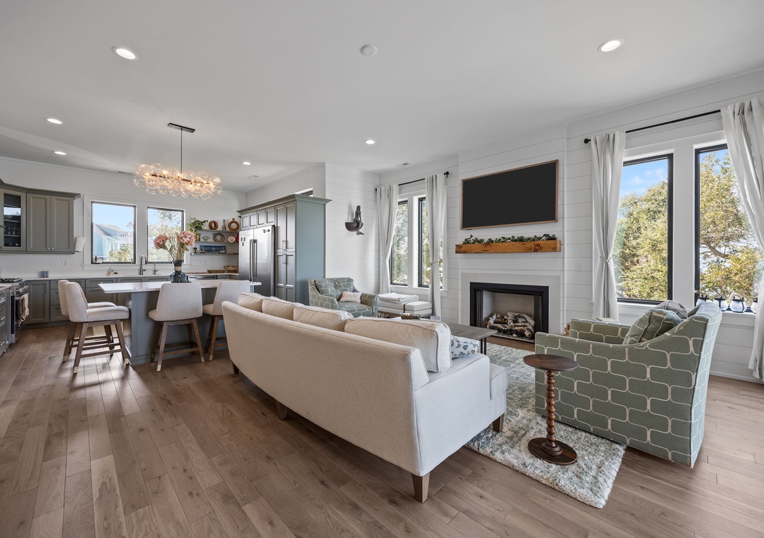 Your open-concept living space blends modern comfort with cozy touches—sink into plush seating by the fireplace while dinner simmers.