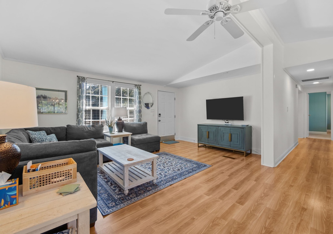 Relax in your spacious living room with plush sectional seating, warm hardwood floors, and modern entertainment center perfect for movie nights.