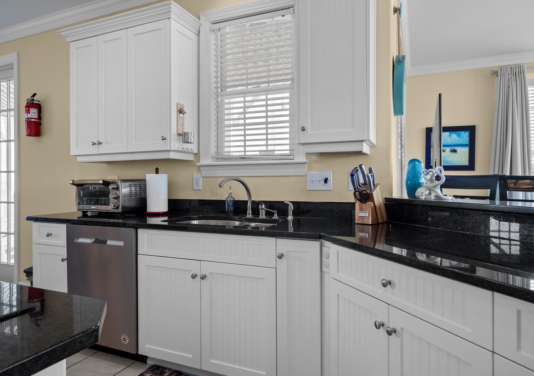 Your fully equipped kitchen features granite countertops, stainless steel appliances, and white cabinetry for effortless meal preparation.