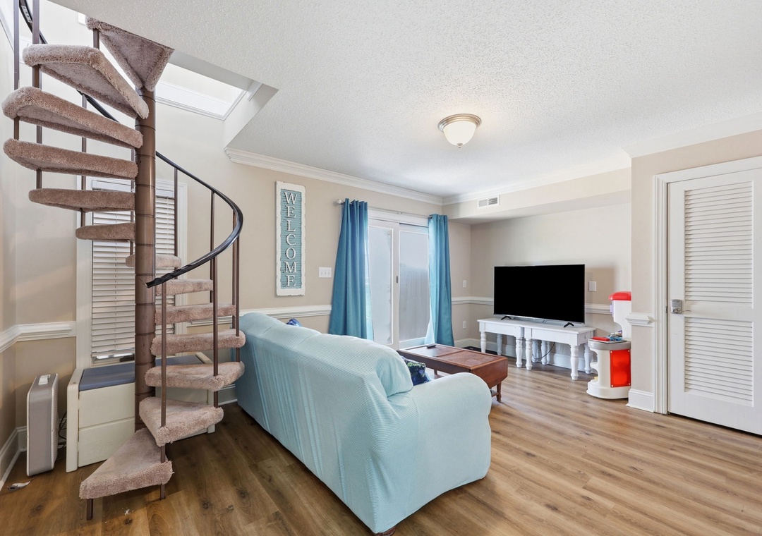 Relax on the plush sofa and enjoy the coastal-inspired living space, where natural light streams in and a charming spiral staircase invites you to explore.