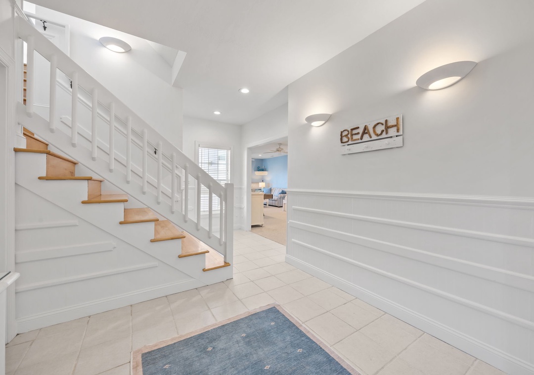 Step into your bright coastal retreat where crisp white walls and warm wood accents create the perfect beach house welcome.