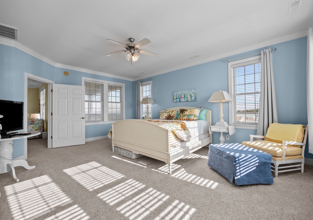 Sink into your coastal-themed bedroom where ocean-blue walls and sunlight streaming through windows create a tranquil retreat for restful nights.