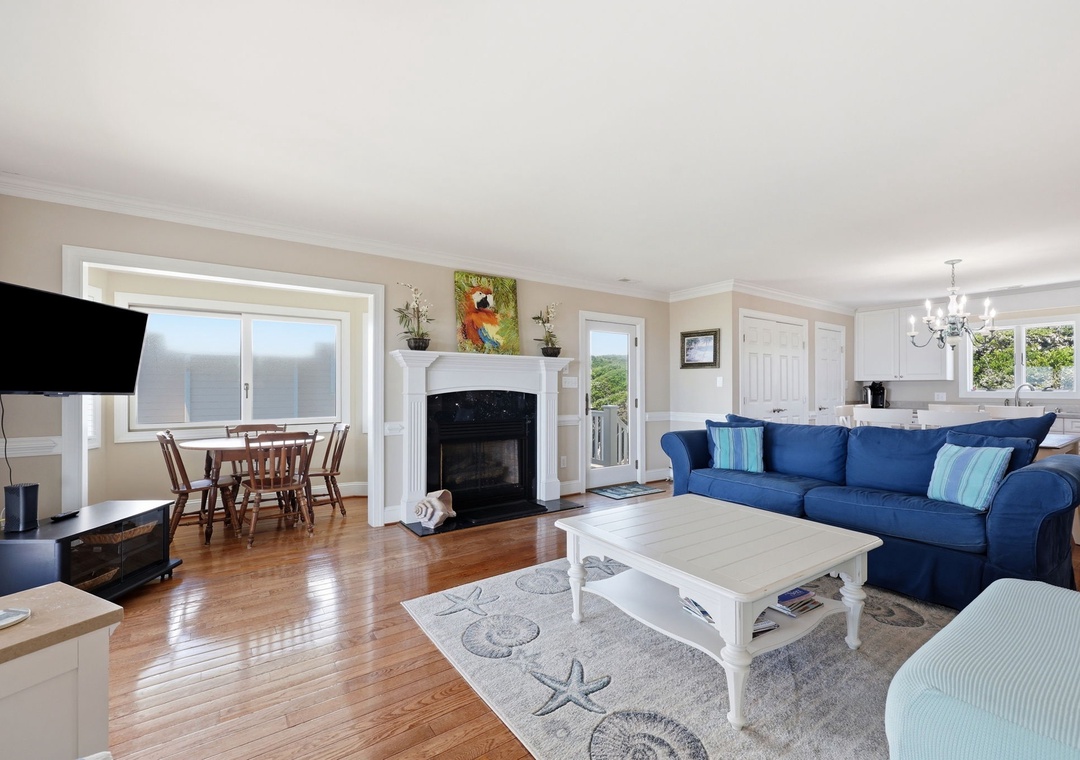 Sink into the plush blue sofa and let the ocean views through bright windows fill your senses. Warm wood floors and coastal touches create your perfect home away from home.