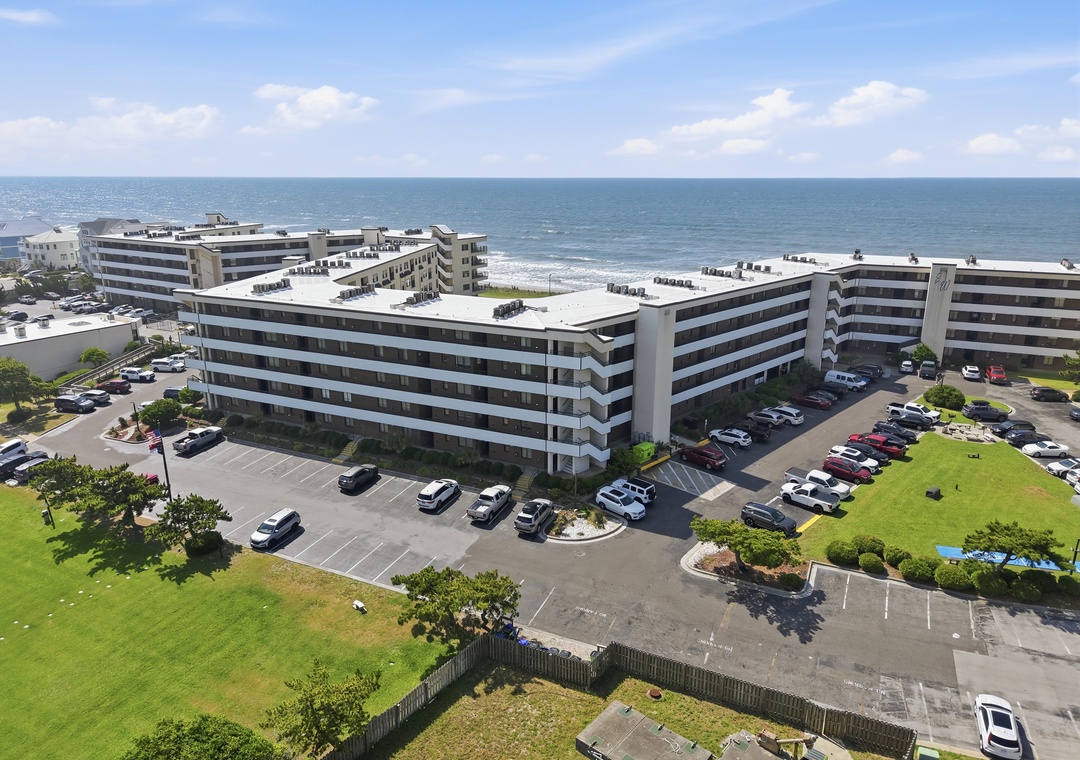Beachfront property complex positioned directly on the sandy shore, surrounded by landscaped grounds and offering convenient parking and coastal access.