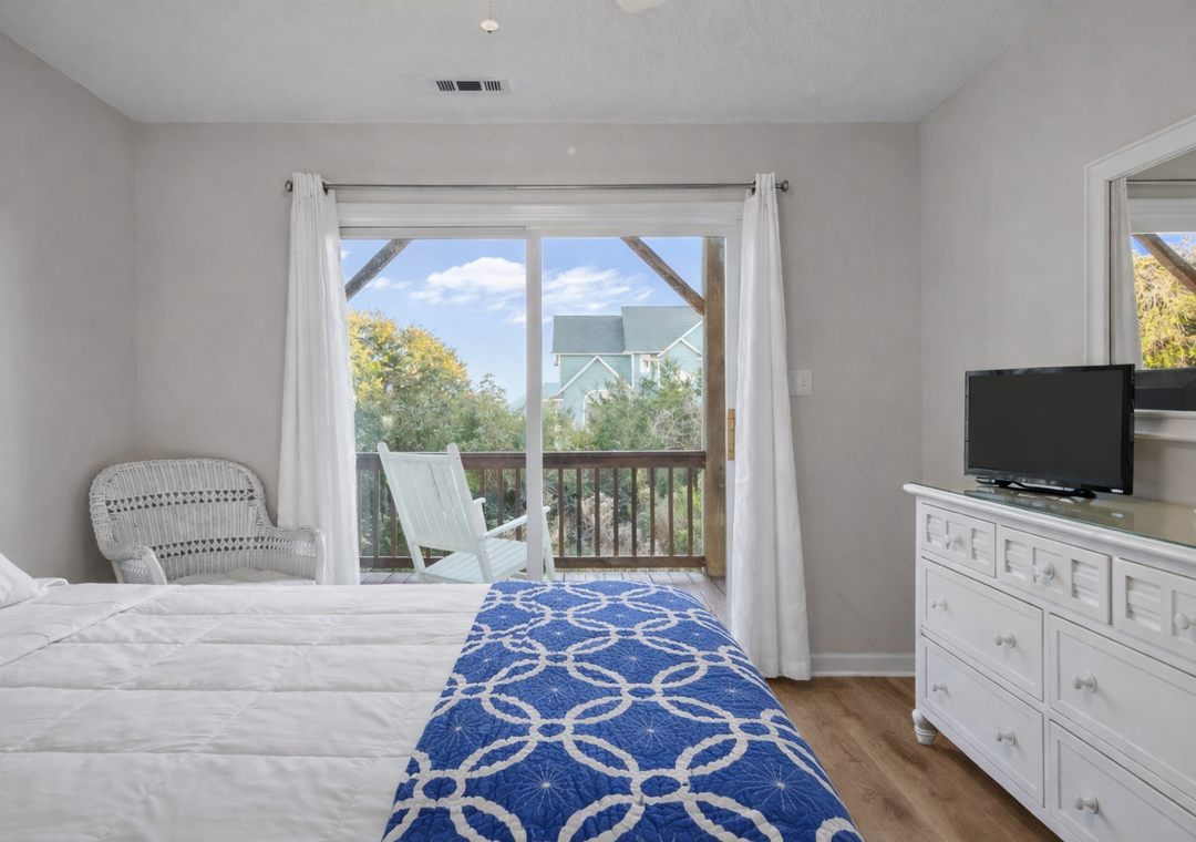Wake up to treetop views from your comfortable bedroom, where coastal charm meets modern comfort with your private balcony overlooking peaceful surroundings.