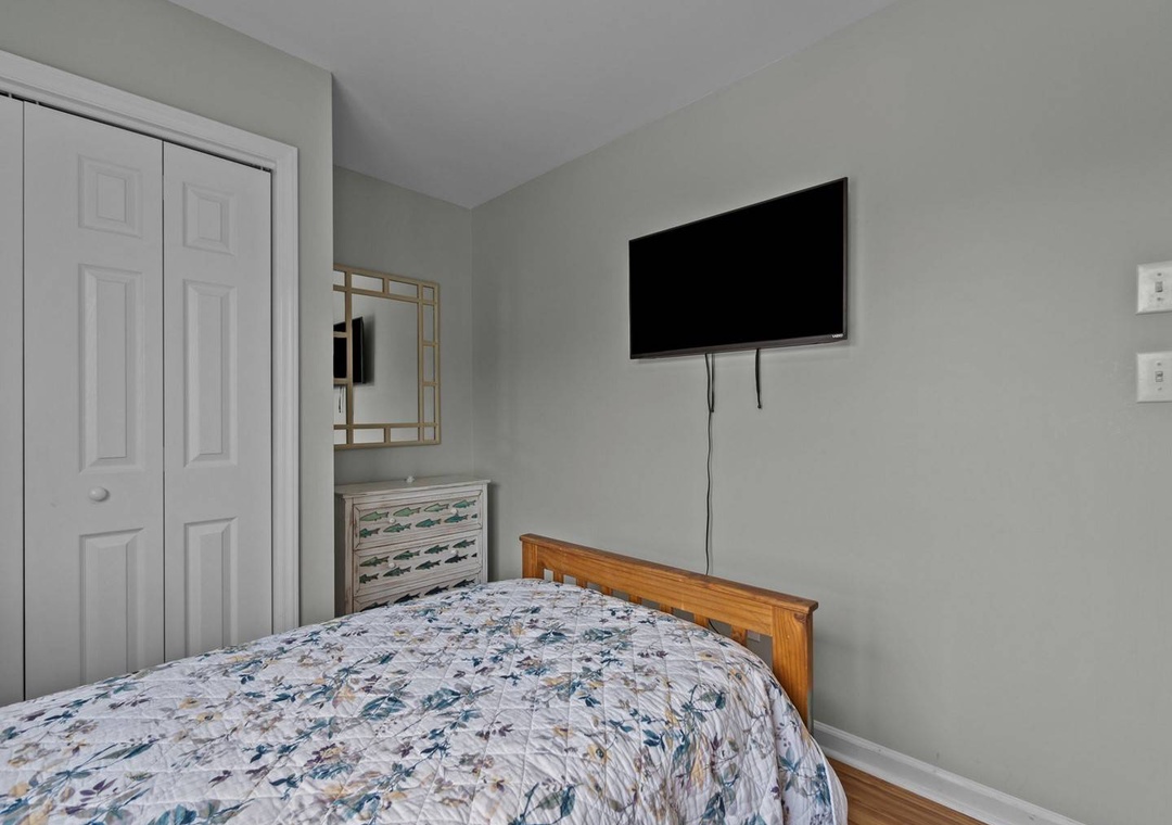 Unwind in your peaceful bedroom featuring a comfortable bed, wall-mounted TV for entertainment, and ample storage space for all your belongings.