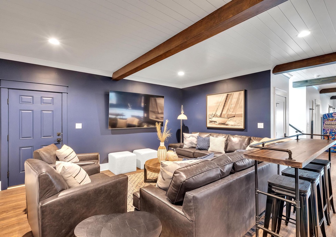 Unwind in your spacious lounge with rich leather seating, natural wood accents, and nautical-inspired art—perfect for relaxing after a day of exploring.