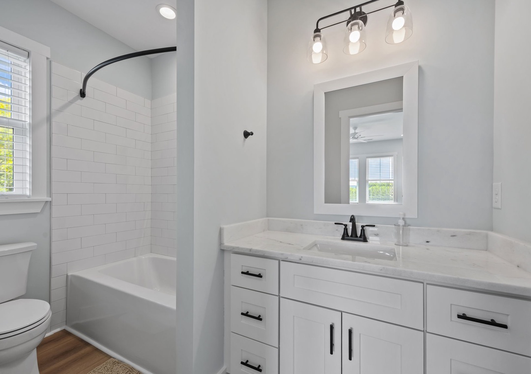 Refresh in your private spa-like bathroom featuring a marble vanity, modern fixtures, and stylish subway tile shower—your perfect morning retreat.