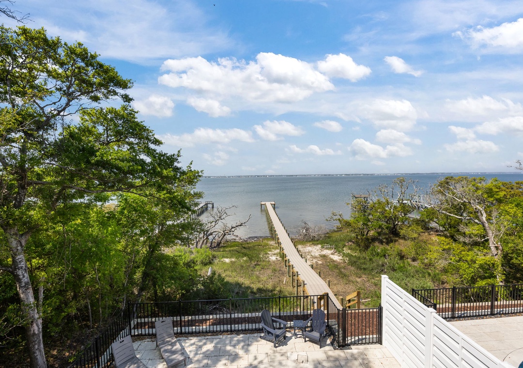 Waterfront property featuring private beach access via wooden boardwalk through natural coastal landscape.