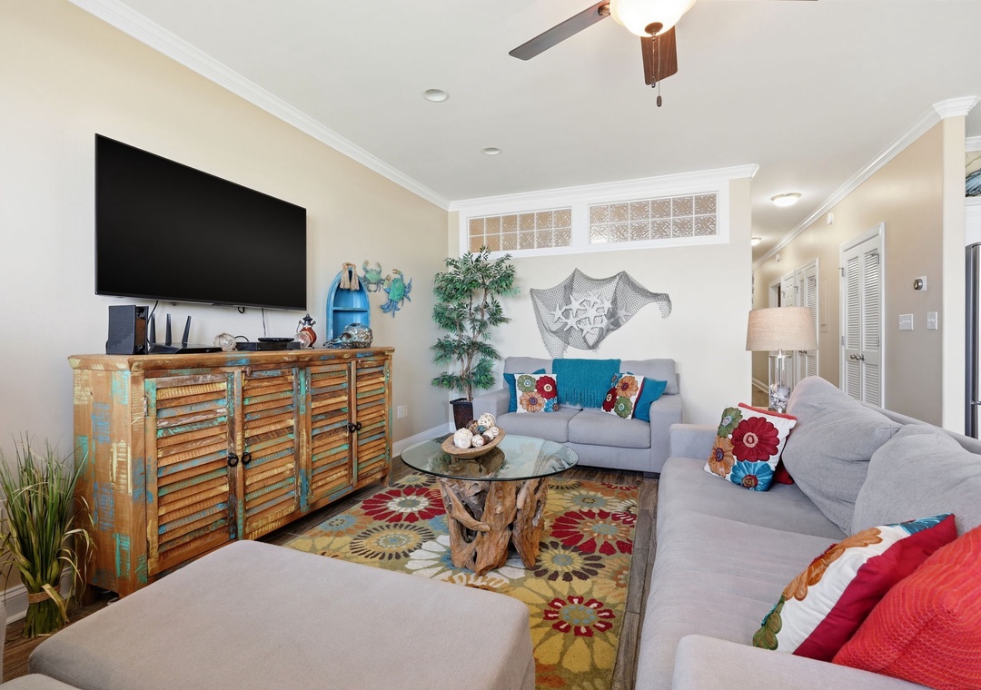 Unwind in this coastal-inspired living room with plush seating, unique driftwood accents, and a large TV for your entertainment. The beachy décor and colorful touches create a relaxed vibe perfect for your vacation retreat.