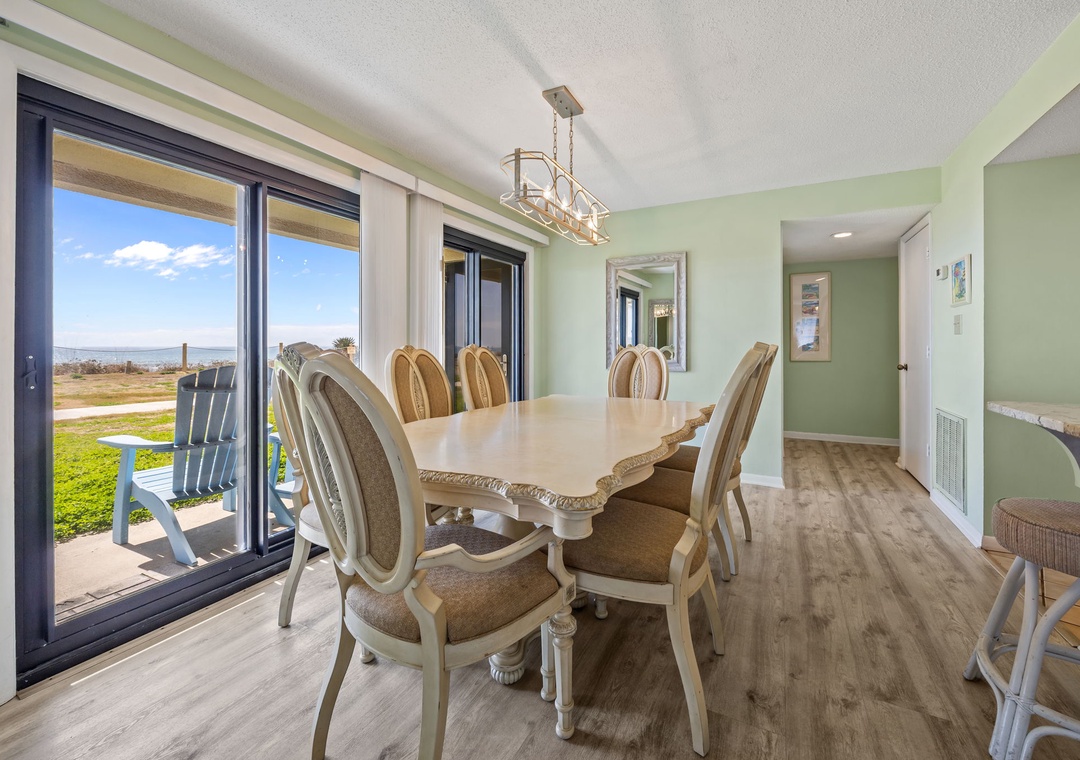 Gather around your elegant dining table with sweeping views through floor-to-ceiling windows, perfect for memorable meals together.