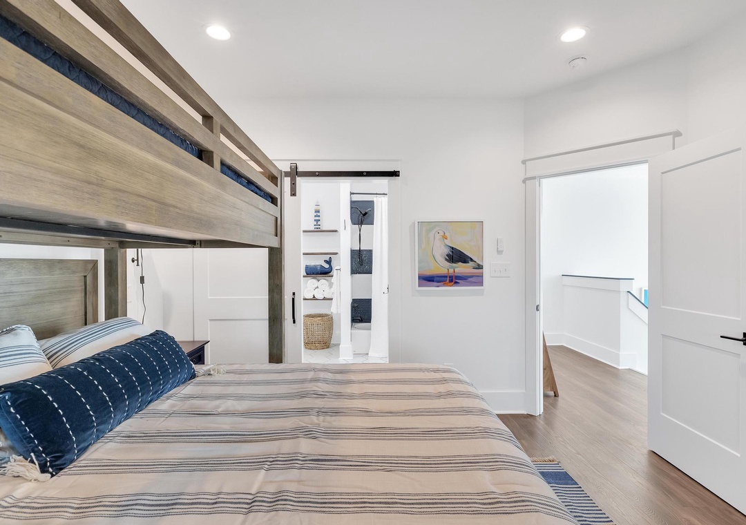 Snuggle into crisp linens beneath a charming bunk, where coastal artwork and natural light create your restful seaside retreat.