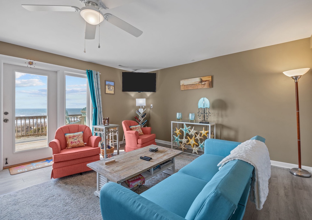 Relax in your bright living room with stunning ocean views through sliding glass doors and cozy seating for memorable moments.