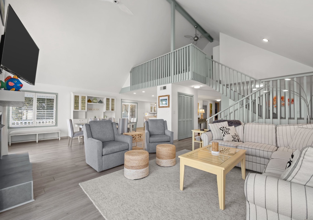 Unwind in this bright, open living space where coastal charm meets modern comfort with stylish furnishings and soaring ceilings.
