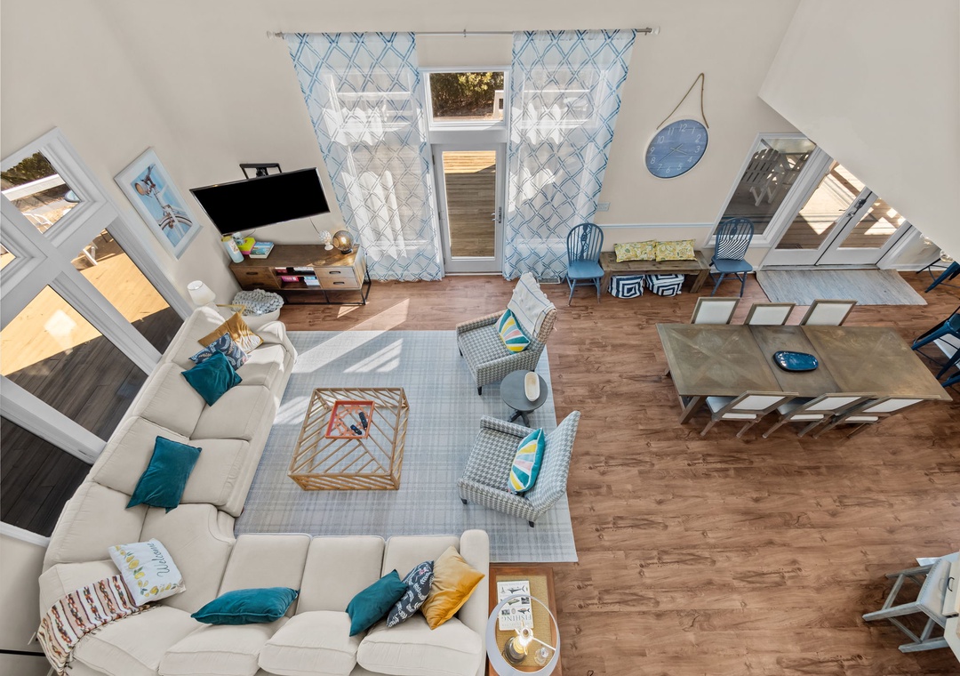 Your airy, modern living space features soaring ceilings, comfortable seating, and abundant natural light streaming through skylights and windows.