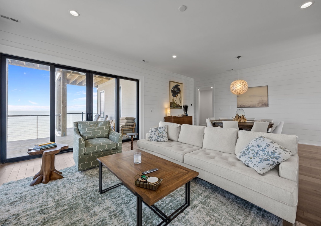Sink into plush seating while ocean breezes flow through your stylish living space, where modern comfort meets breathtaking coastal views.