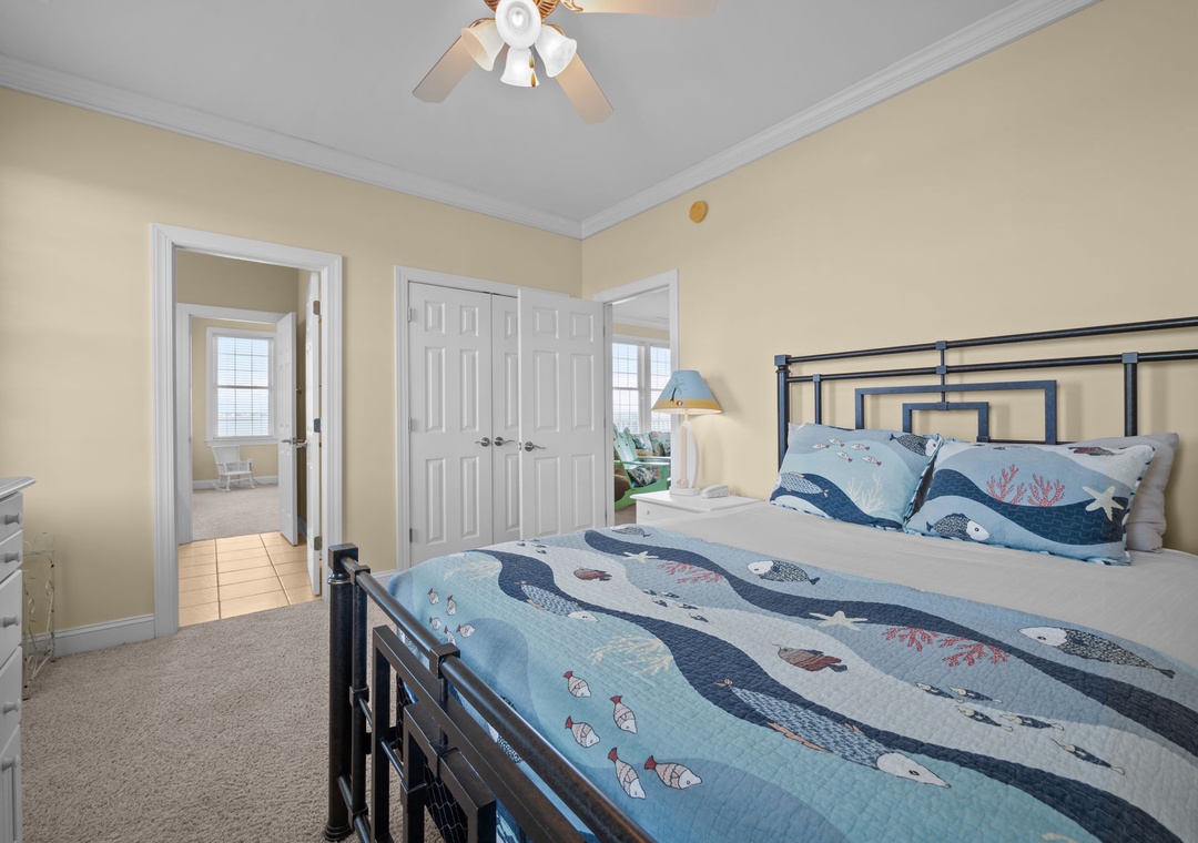 Drift off to sleep in your cozy coastal-themed bedroom, where ocean-inspired bedding and gentle ceiling fan create perfect comfort.