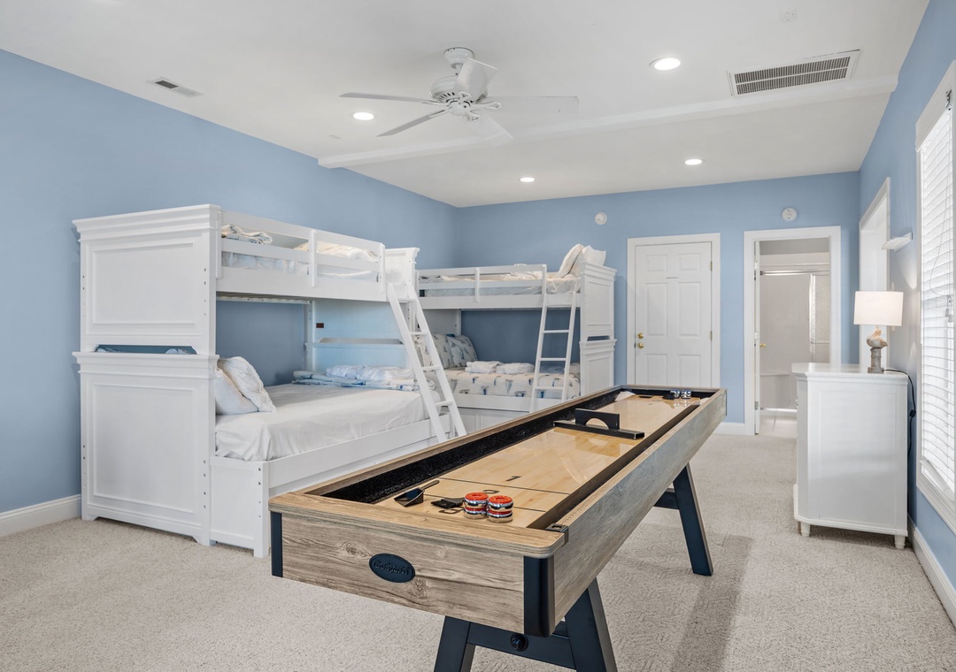 Your kids will love this cheerful bedroom with bunk beds and a shuffleboard table for endless fun.