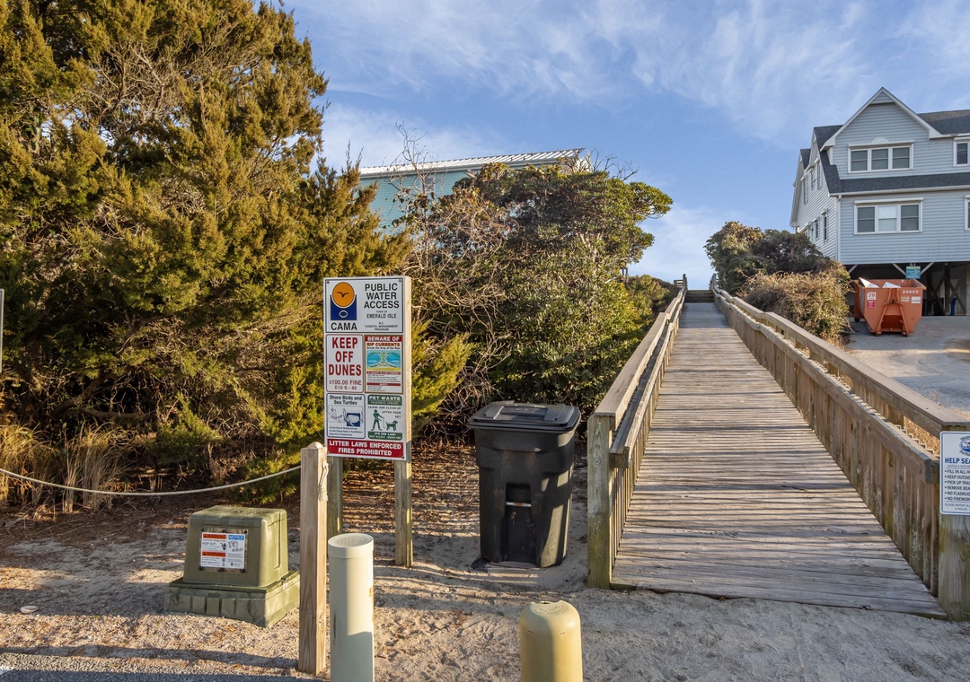 Coastal beach access with boardwalk and nearby vacation homes in a quiet residential area.