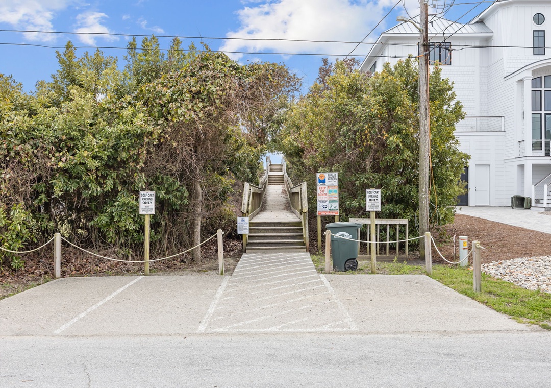 Beach access pathway with wooden boardwalk leading through coastal vegetation near the property.
