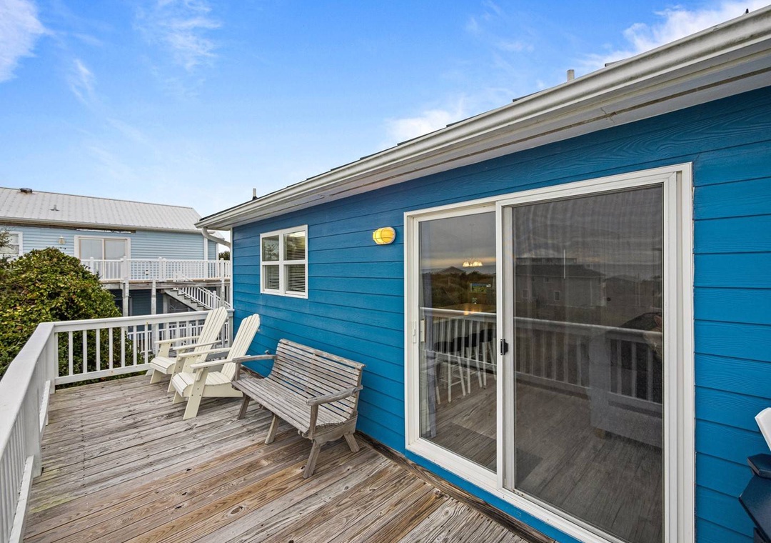 Relax on your private deck with comfortable seating and sliding door access to your coastal retreat.
