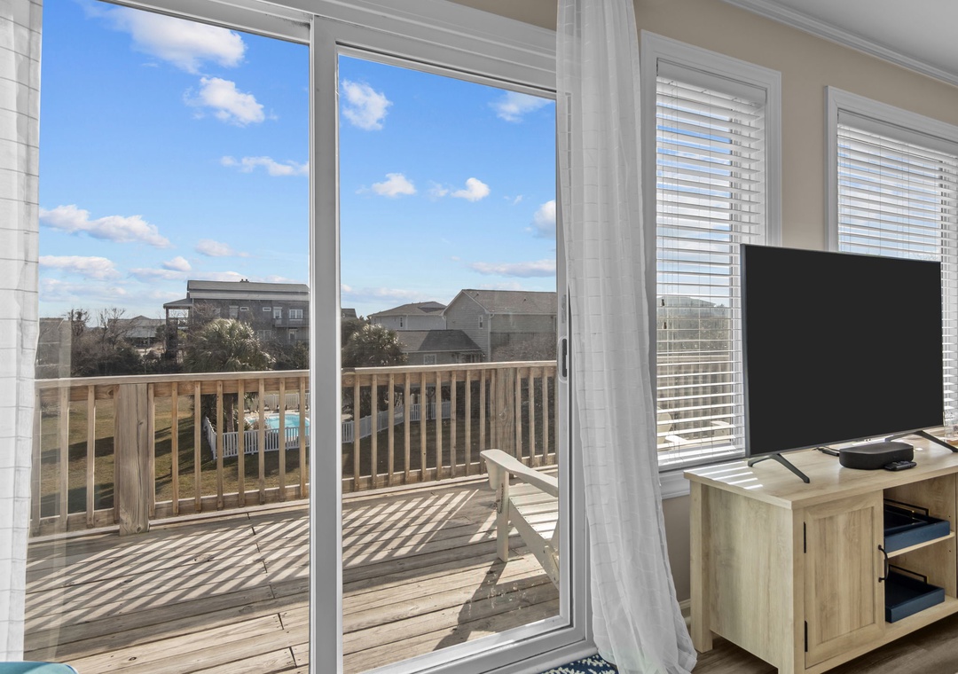 Enjoy peaceful mornings with your coffee on this sunny deck, overlooking the quiet neighborhood through floor-to-ceiling windows.