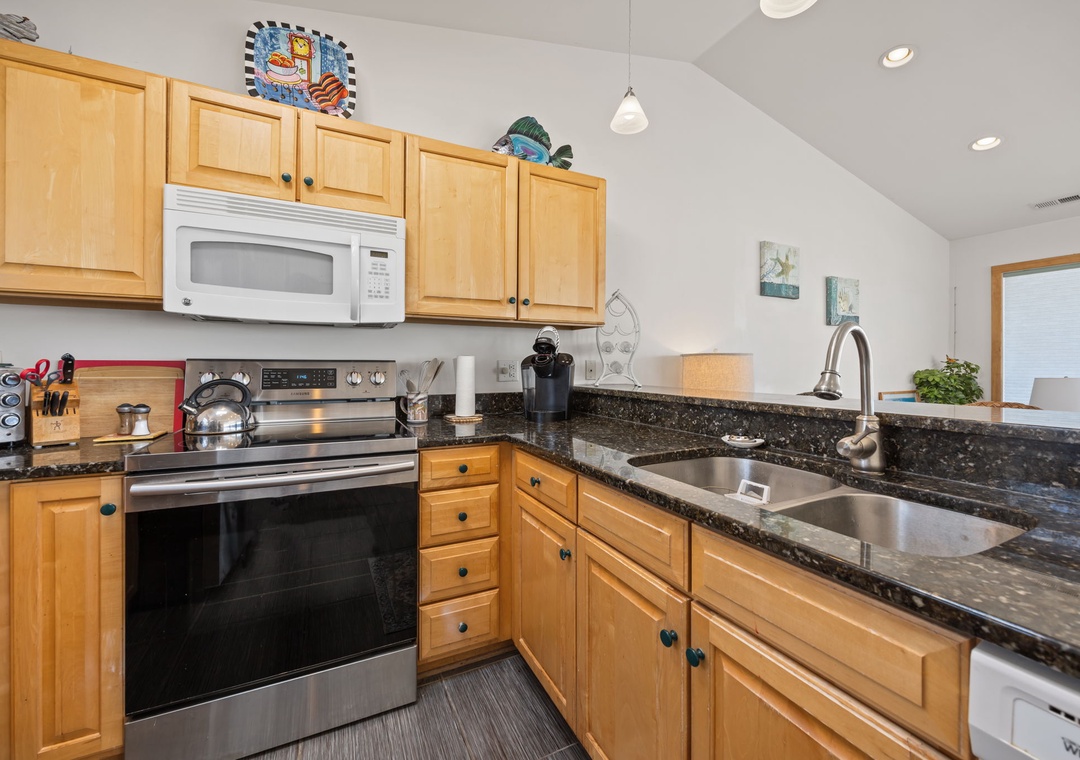 Your fully equipped kitchen features granite countertops, stainless steel appliances, and warm wood cabinetry—perfect for creating memorable meals together.